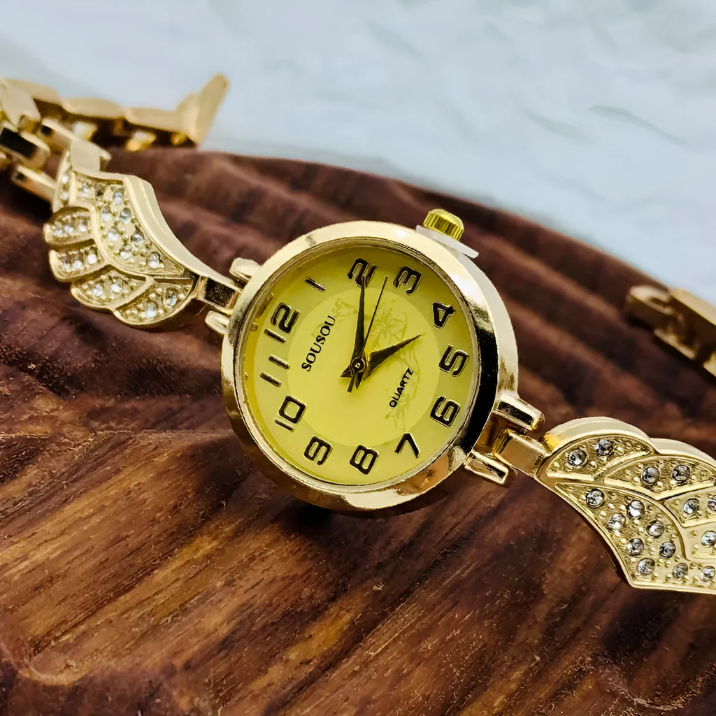 Stainless steel women's wristwatch with a round dial and vachette clasp, showing a gold-coloured surface.