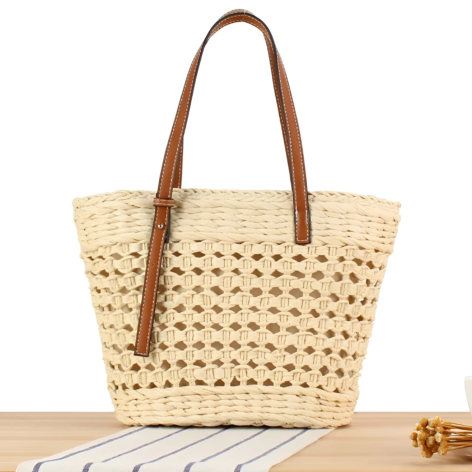 Beige paper-string woven shoulder bag with adjustable strap showing horizontal square design and straw elements