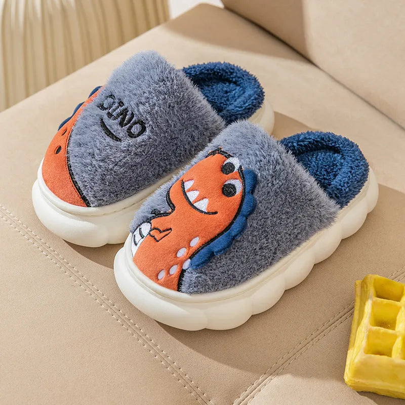 A pair of plush grey dinosaur-themed cotton slippers with a thickened sole for indoor wear.