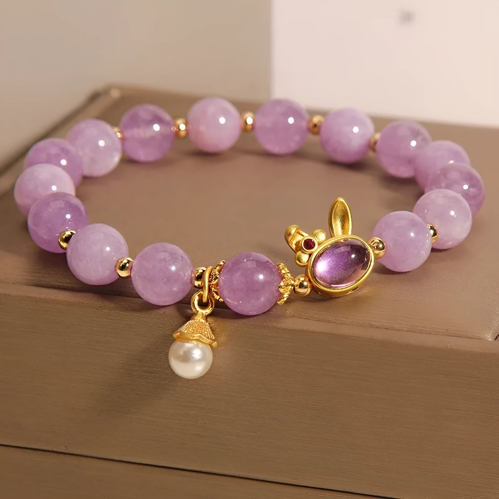 Purplish red mauve jade rabbit head charm on a clear crystal bracelet, Mori style design.