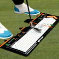 Black neoprene golf swing stance alignment pad on grass