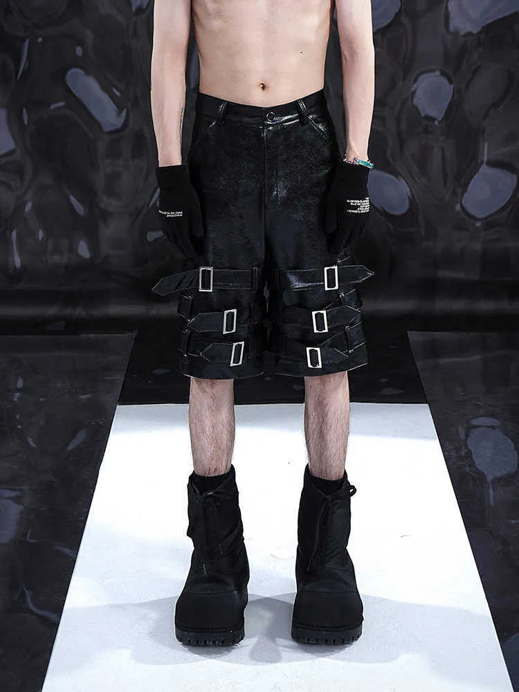 Black men's PU leather cropped pants on hanger showing low waist and flexible spandex material.
