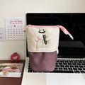 Brown cartoon pattern collapsible pencil case with zipper closure showing interior space