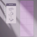 A folded and unfolded purple TPE gymnastic mat on a wooden floor.