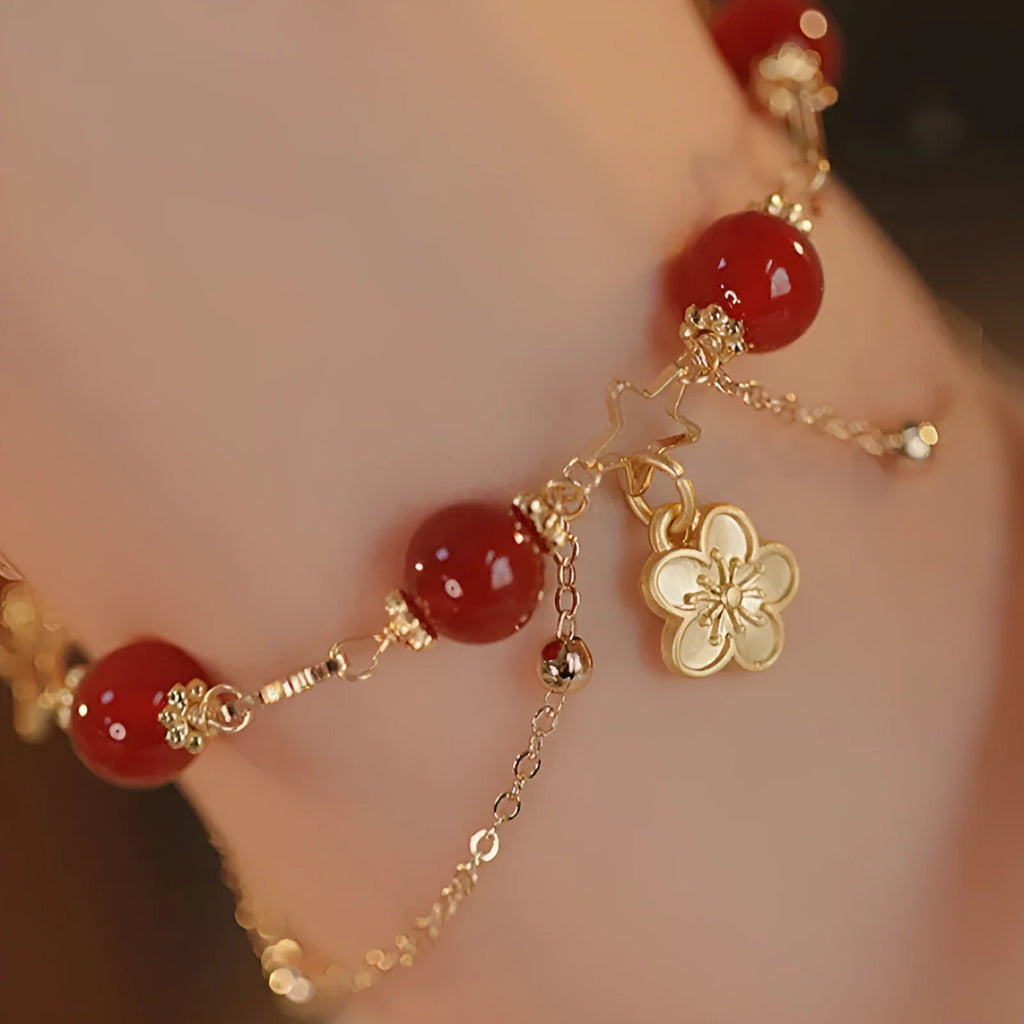 Red agate double layer bracelet with floral and peach blossom detailing on woman's wrist