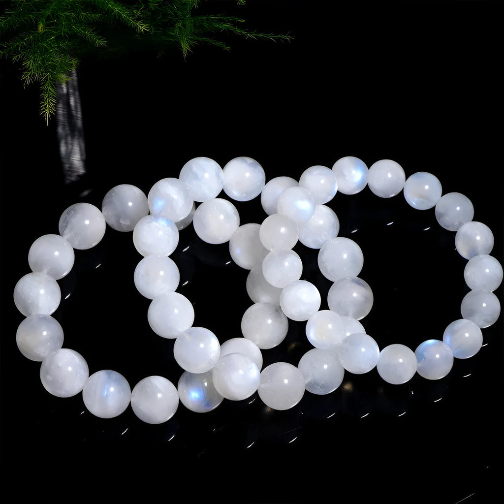 Natural blue moonlight polished moonstone round bead bracelet on wrist.
