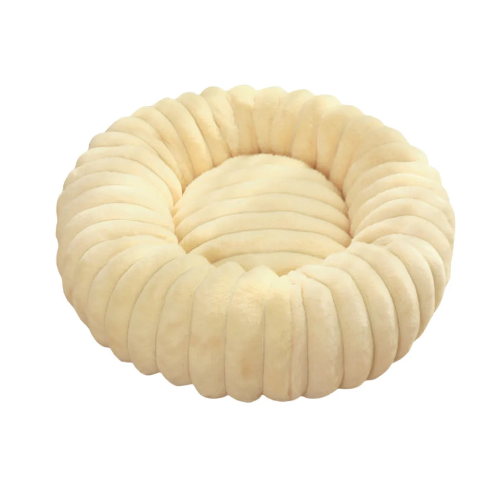 A round, plush beige pet nest bed for cats or dogs on a wooden floor.