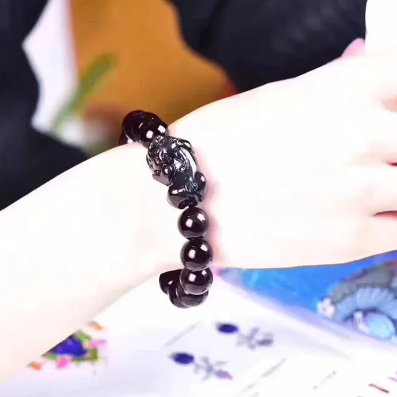 Natural eye obsidian crystal bracelet with ice colour tones and silver clasp on a wrist.