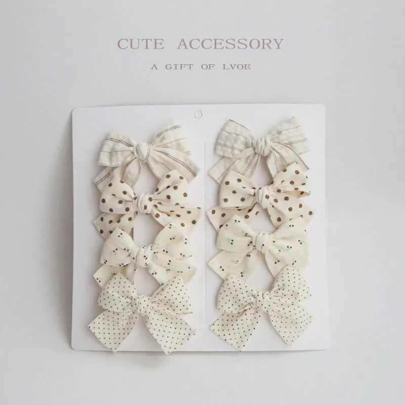Children's fabric dovetail bow hairclips set showing multiple colour and pattern options