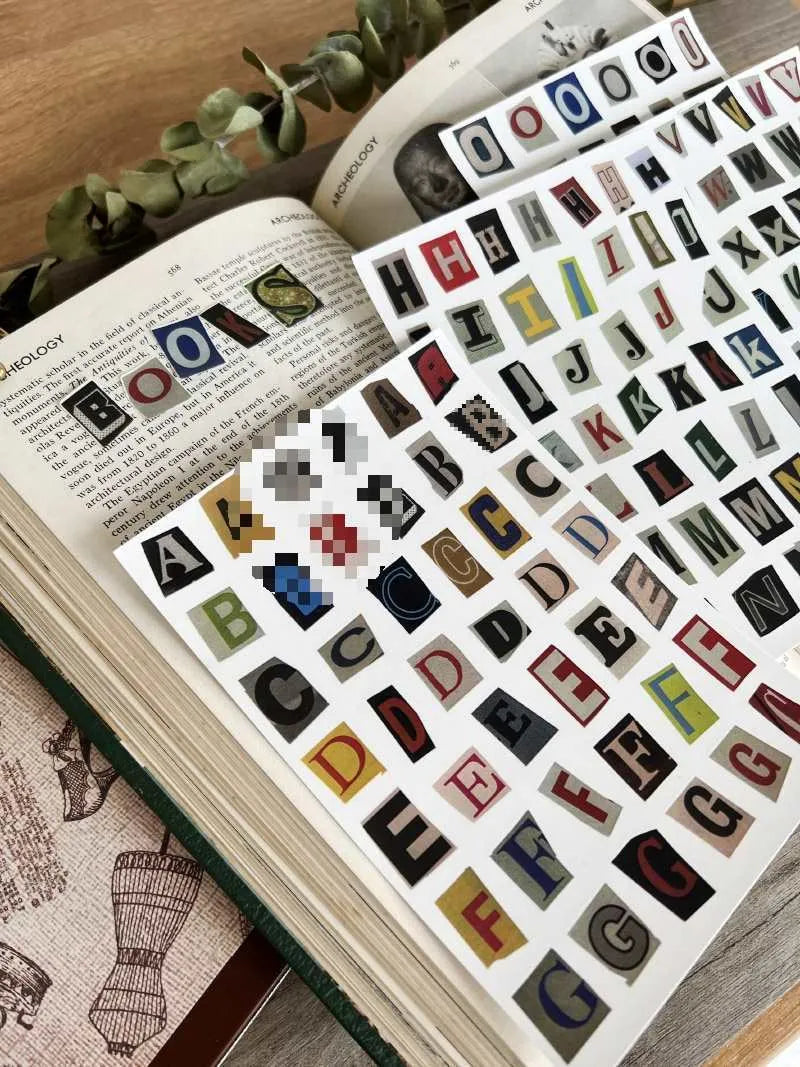 Sheets of cute printed stickers showing English letters A to Z, numbers, symbols, and weekly words like Monday and Friday.