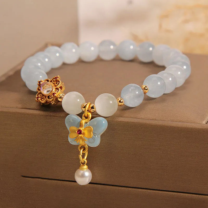 Women's crystal bracelet with aquamarine butterfly pendant and rhinestone detailing.