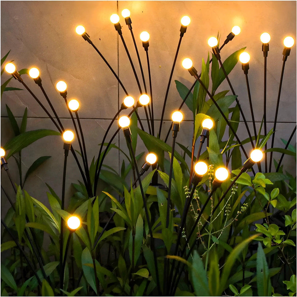 Solar-powered LED garden light with multiple heads on a stainless steel stake, placed in soil.