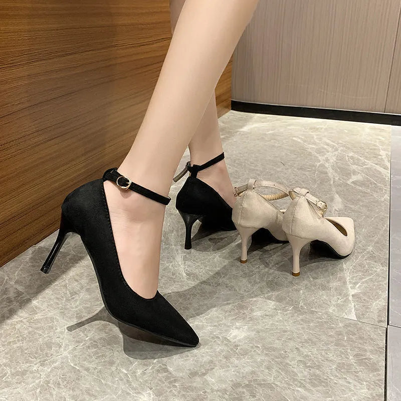 Black and creamy white women's stiletto heel pumps with buckle closure and skull pattern.