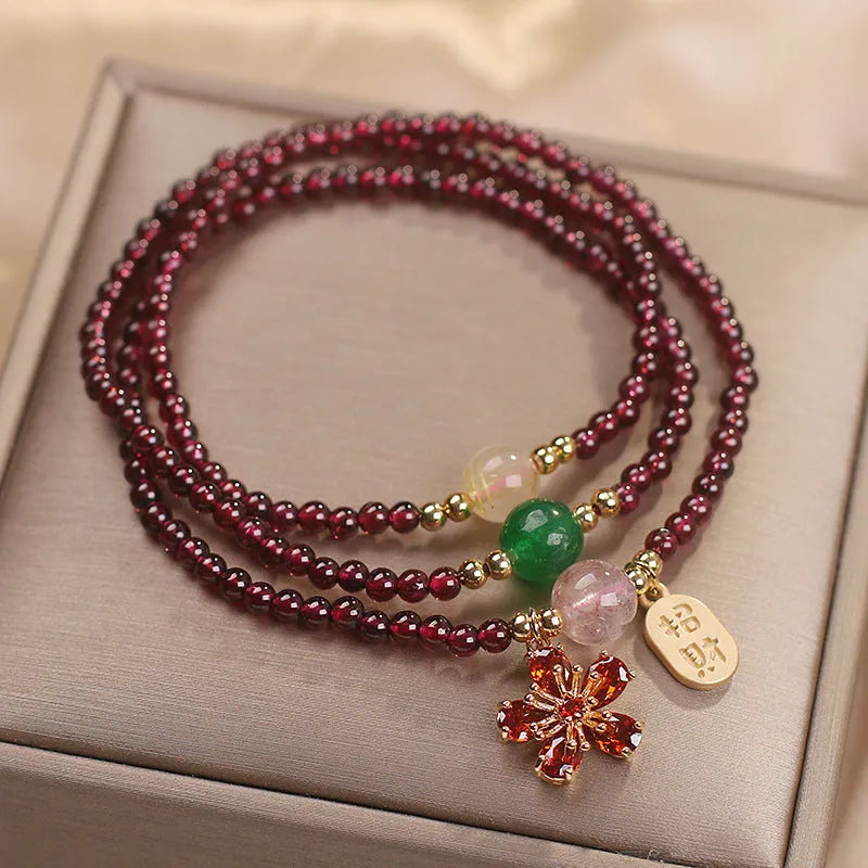 Women's simple bracelet made of red crystal with sequin accents on a wrist.