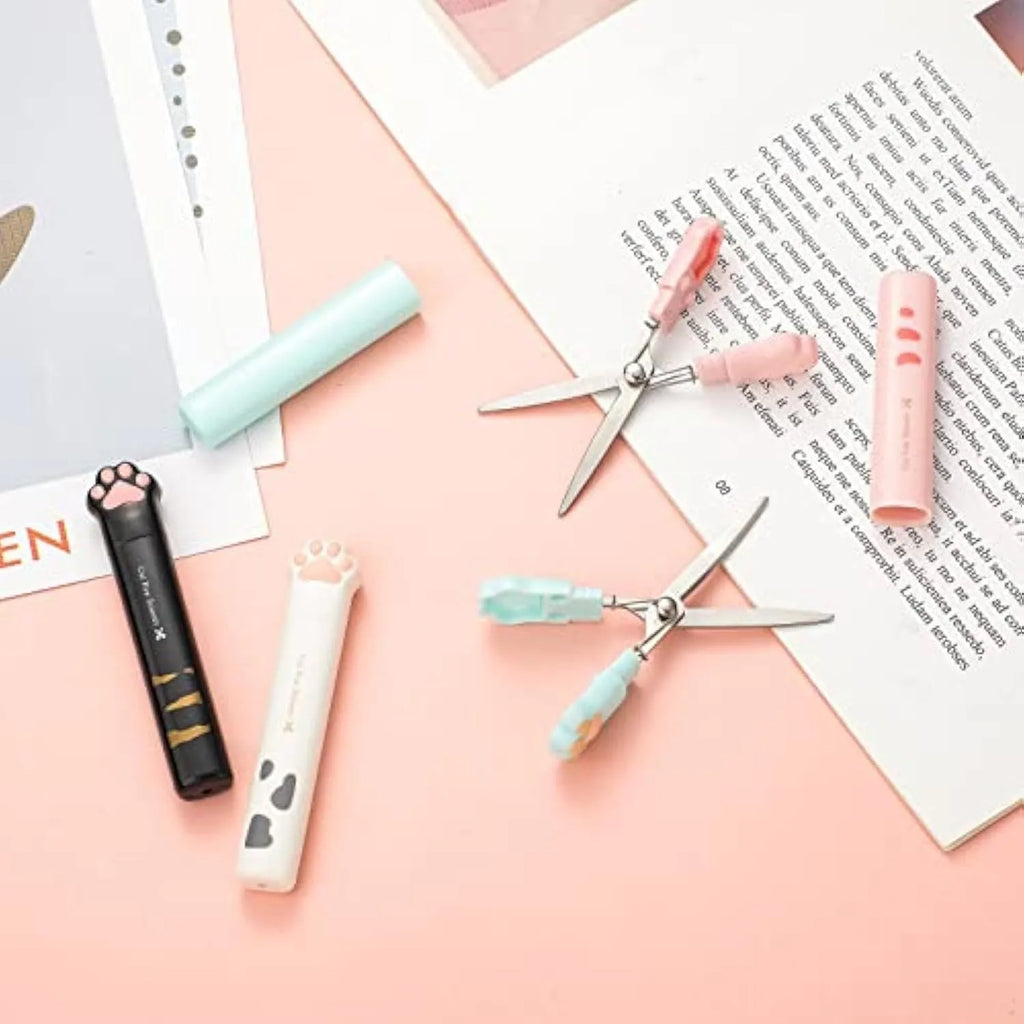 Closed and open views of cute cat paw design mini folding safety scissors on a craft background.