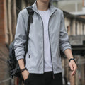 Man wearing a loose-fit grey Korean-style lapel casual jacket with zipper pockets.