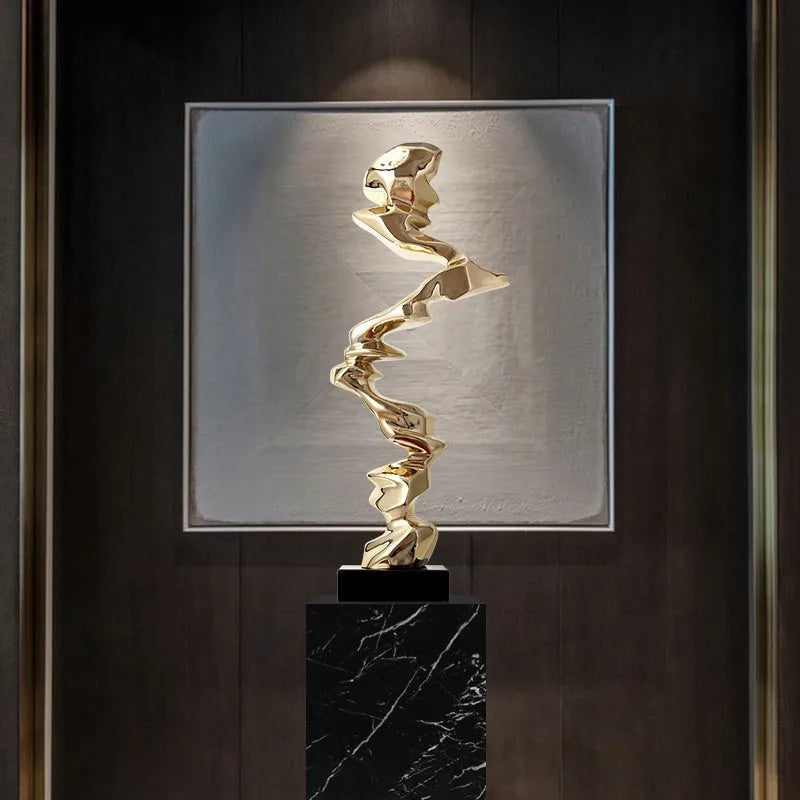 Minimalist abstract still life ornament in natural resin on a shelf, shown in bright gold finish.