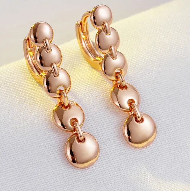 Gold retro long woven copper circle hoop earrings on a white background