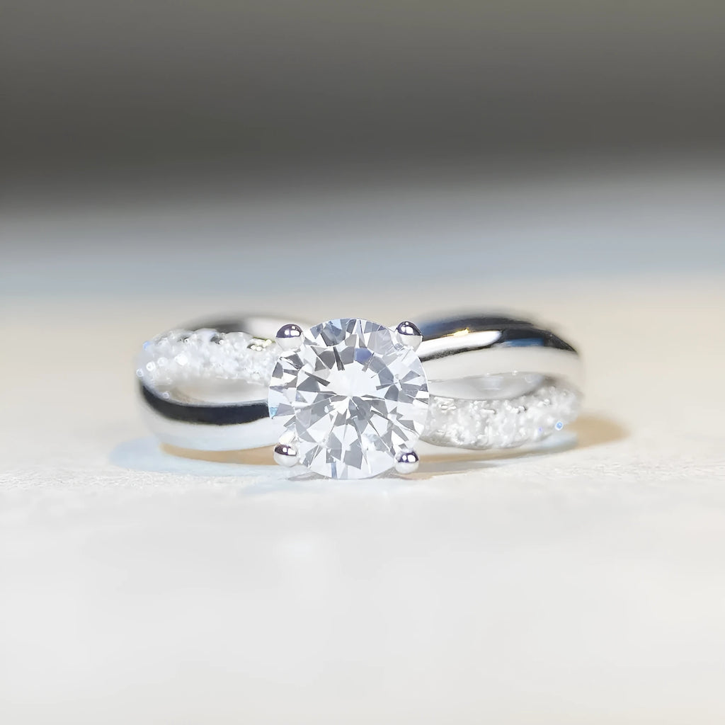 Geometric twisted silver band ring with 1 karat moissanite stone in four-claw setting, side view showing cross details