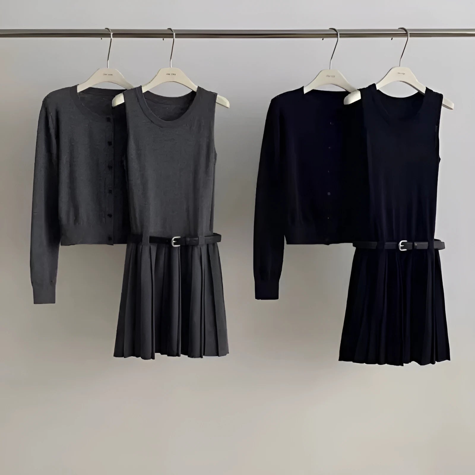 Women's grey art retro knitted vest skirt and long sleeve cardigan two-piece set on a hanger.