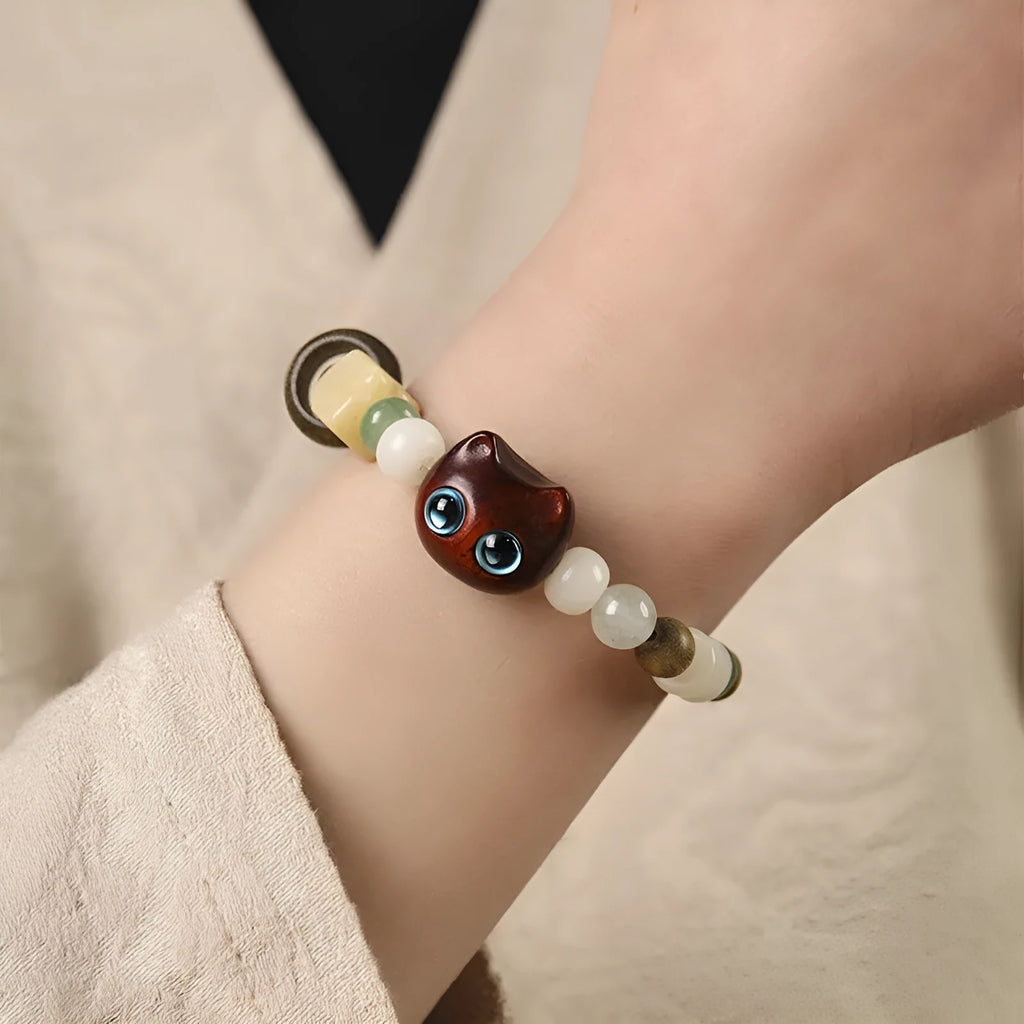 Hand-woven bracelet with jade guajacwood multi-treasure cube and cat's paw design in bodhi and ebony materials