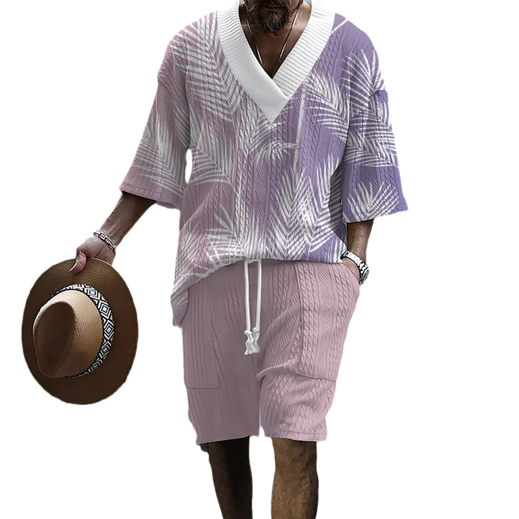 A man wearing a printed drop-shoulder knitted top and matching shorts from a casual two-piece loungewear set.