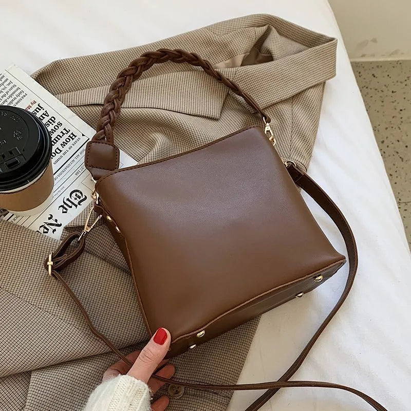 Retro woven PU leather crossbody bucket bag in an androgynous style.