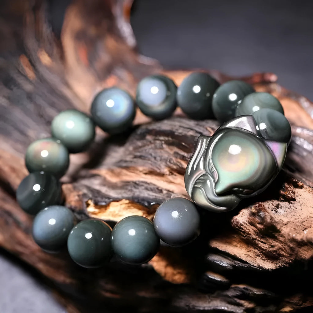 Obsidian stone bracelet with carved fox design in cartoon style, showing dark stone colouration