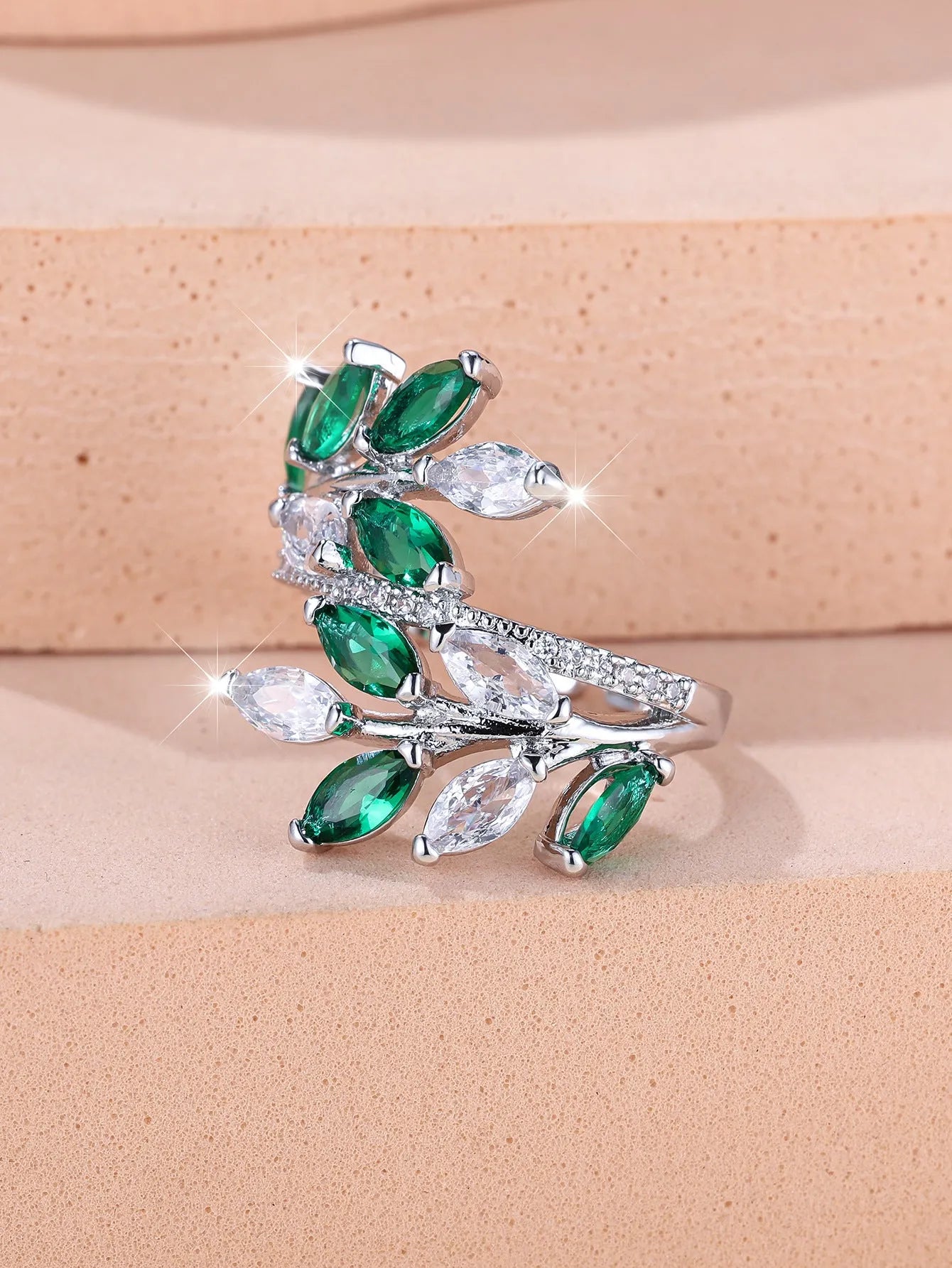 Adjustable open-ended leaf-shaped ring with zirconia stones on a copper band.