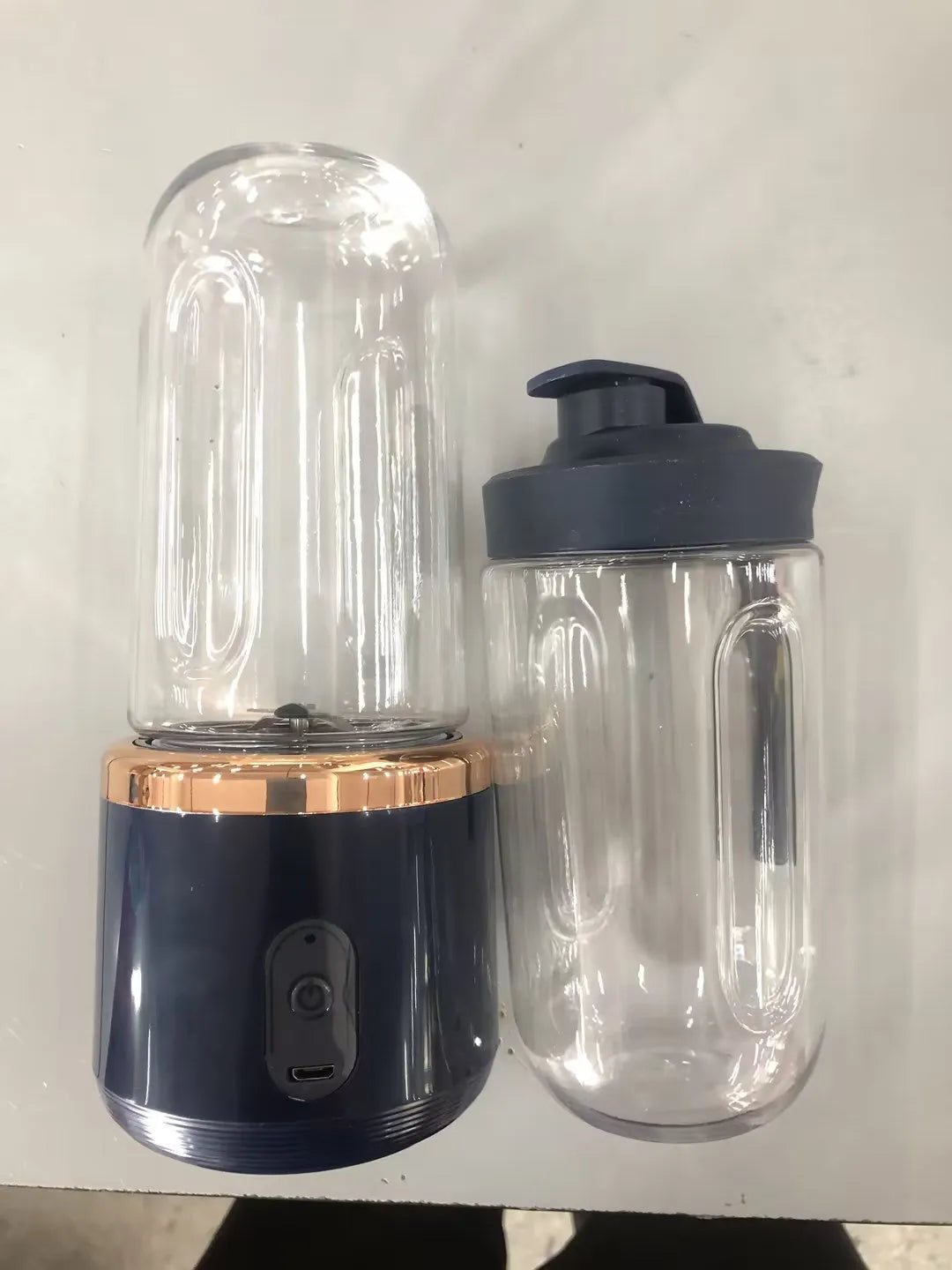 Portable dark blue blender and juicer with six blades, USB charging cable, and 400ml plastic cup.