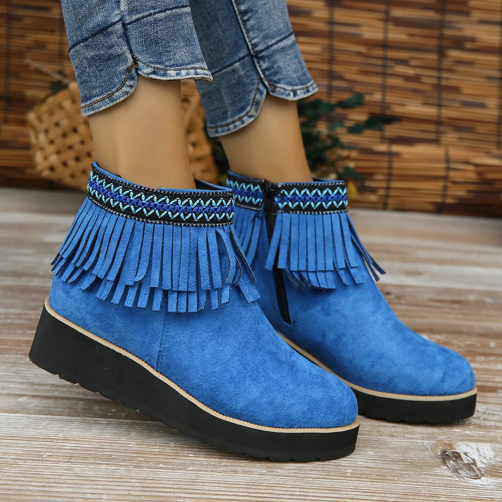 Women's dark brown suede wedge ankle boots with side zip and tassel detail on a thick rubber sole.