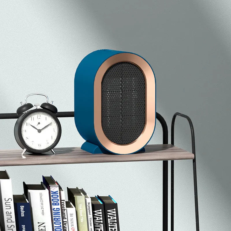 Compact black desktop electric fan heater with a front grille and mechanical control dial.