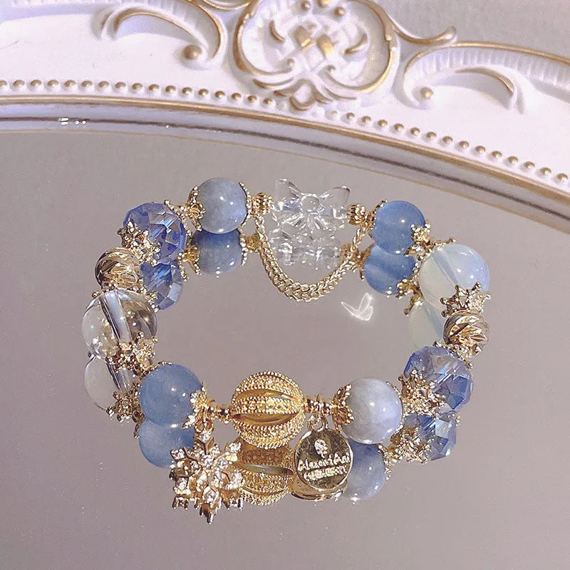 Galaxy-coloured alloy charm bracelet with snowflake, heart, and bow pendants.