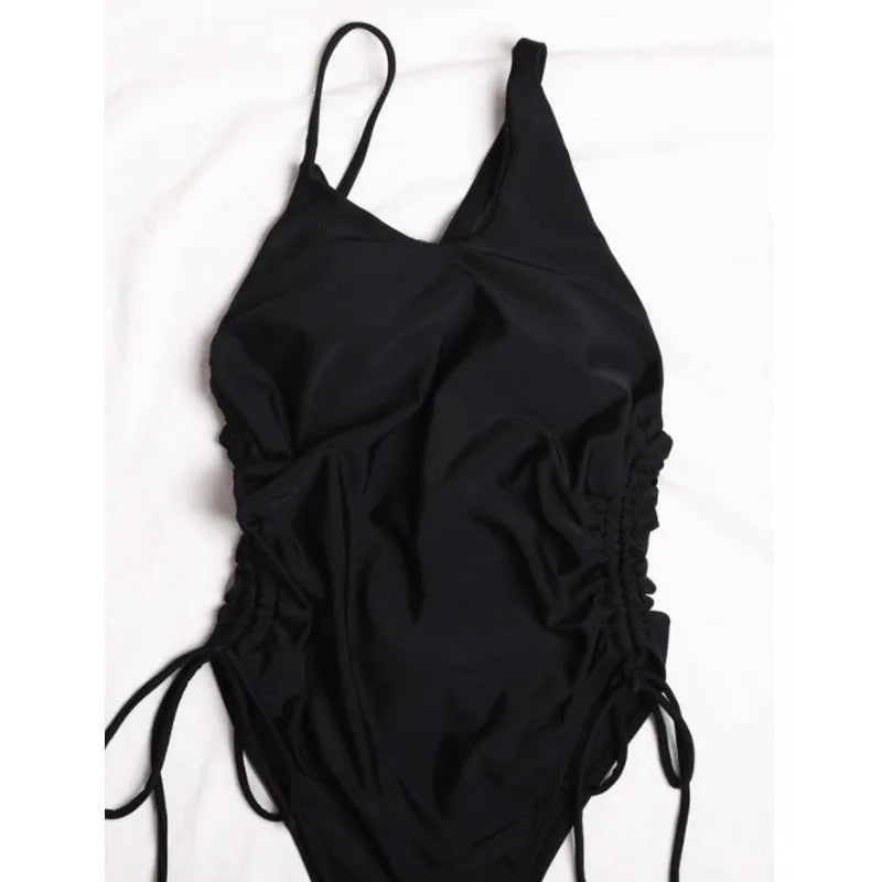 Black sleeveless women's dress with sloping shoulders and lacing detail on a tight fit.