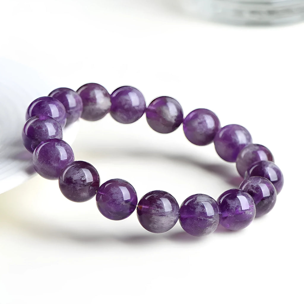 Snow Mountain Feather Amethyst crystal bracelet with scattered geometry beads and Ruyi design on a wrist.