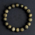 Natural obsidian crater ball bracelet with textured beads on a wrist, showing silver stone meteorite colour variant.