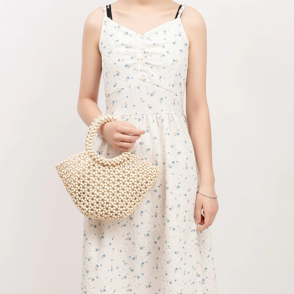 Hand-woven maple beach handbag with wooden beads in dumpling shape, shown in milky white colour
