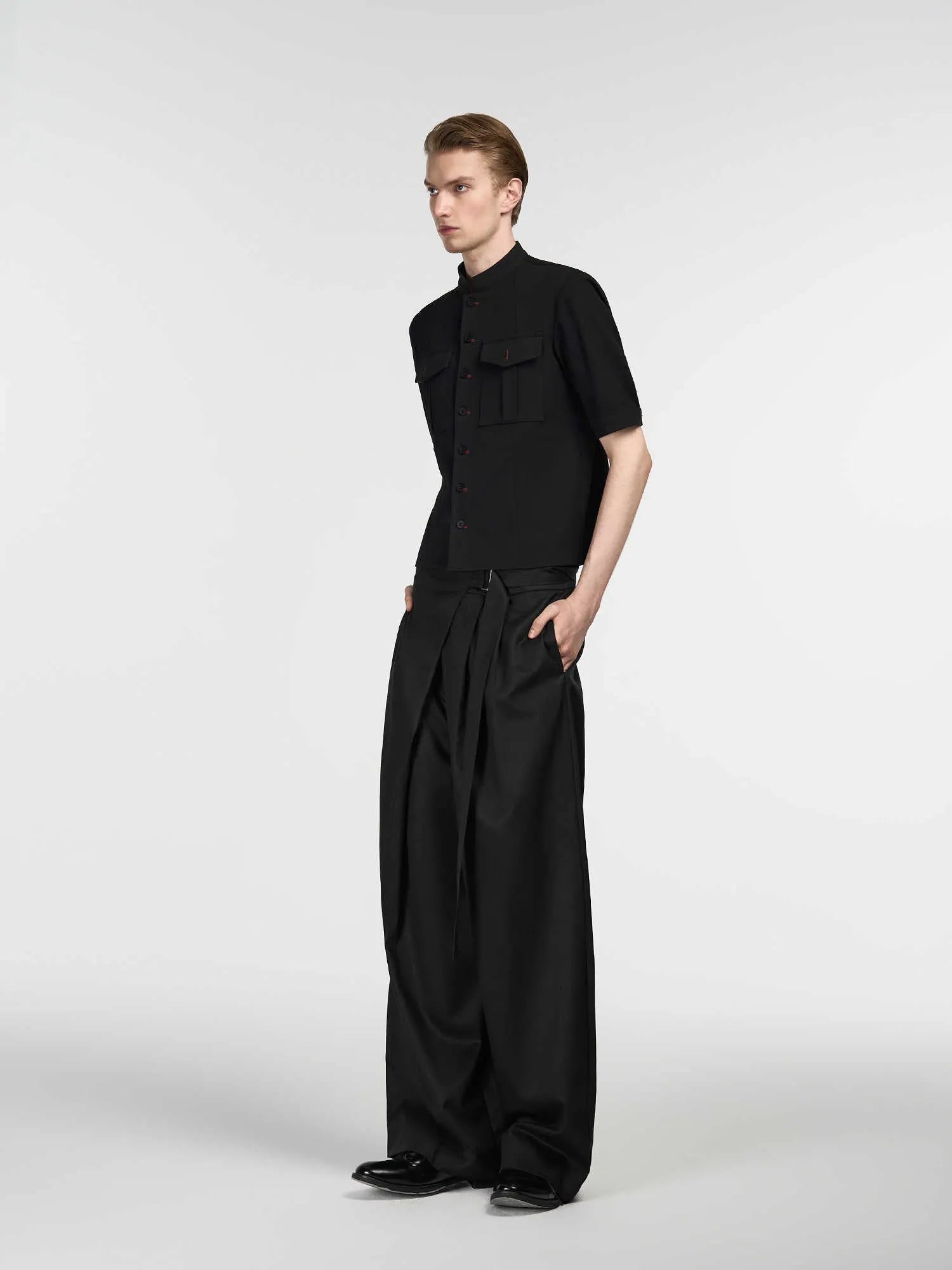 Black straight-leg trousers with a single pleat and adjustable waistband, made from a Tencel and cotton blend fabric.