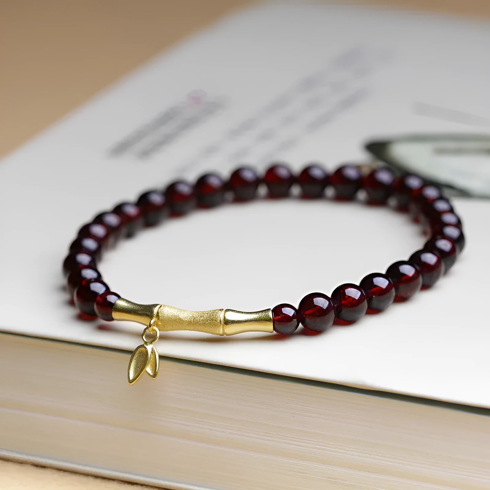 Natural garnet stone set in a 6mm wide bamboo joint bracelet with copper or silver metal finish.
