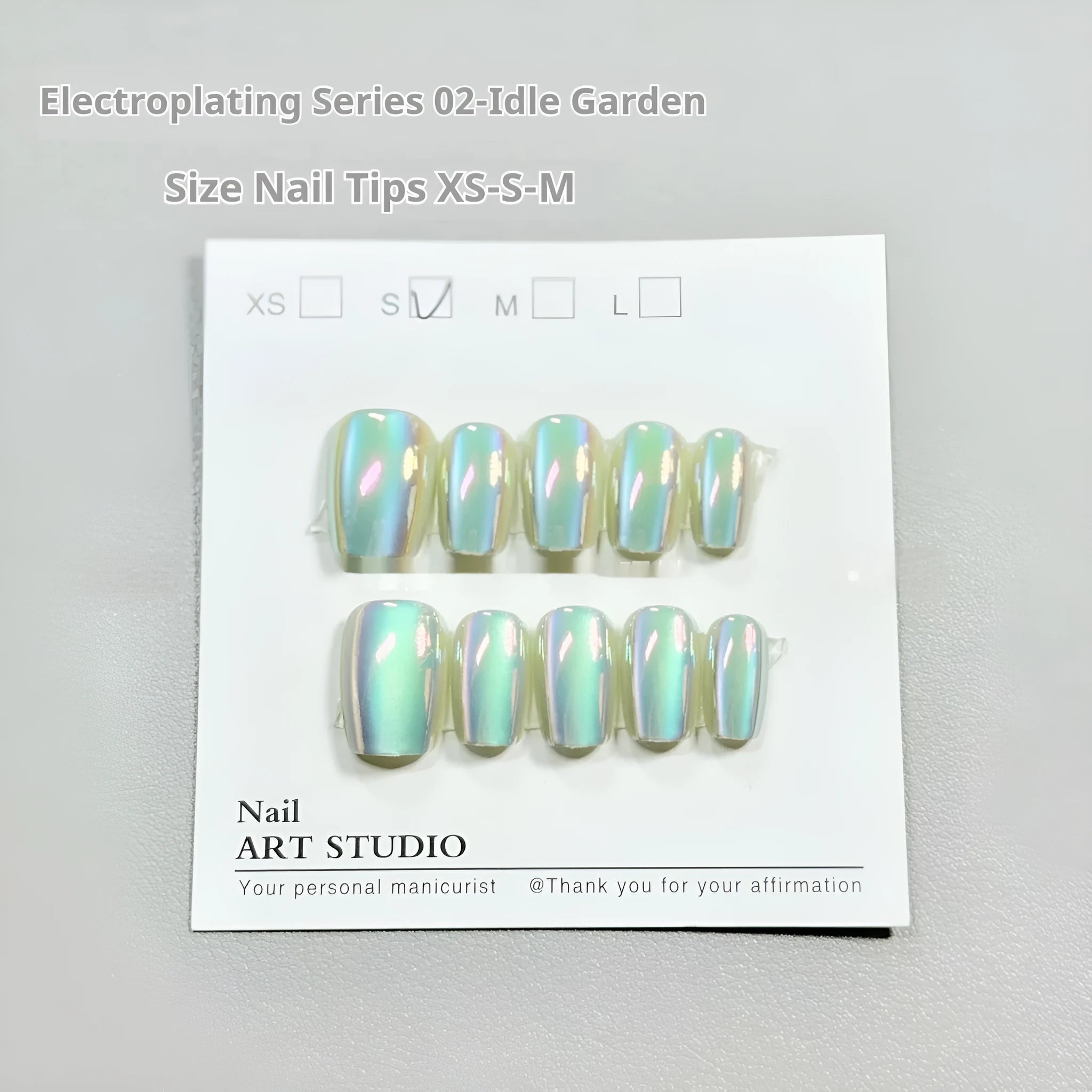 Set of electroplated Cat's Eye and Aurora effect press-on false nails in short ladder shape on a white background.