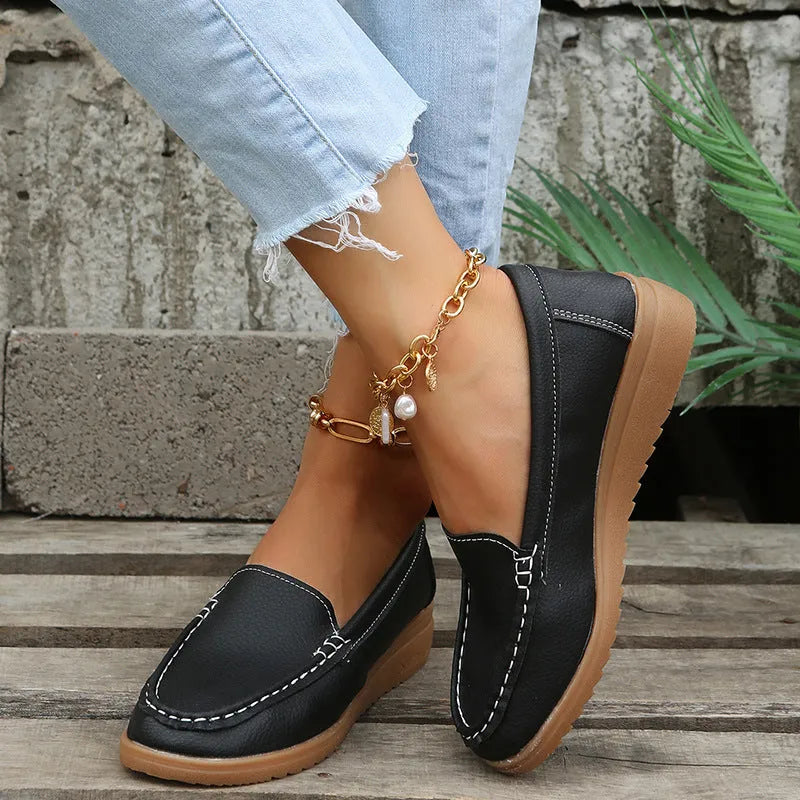 Women's flat PU leather loafers in multiple colours showing round toe and car suture detail.