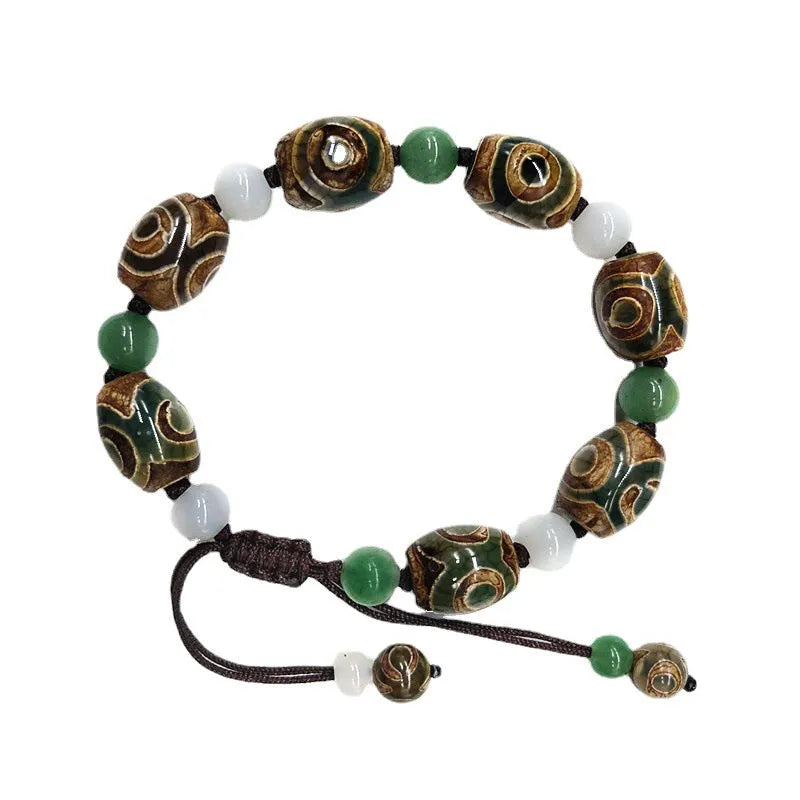 Green agate hand-woven Tibetan bracelet with three-eye geometric design on a wrist.