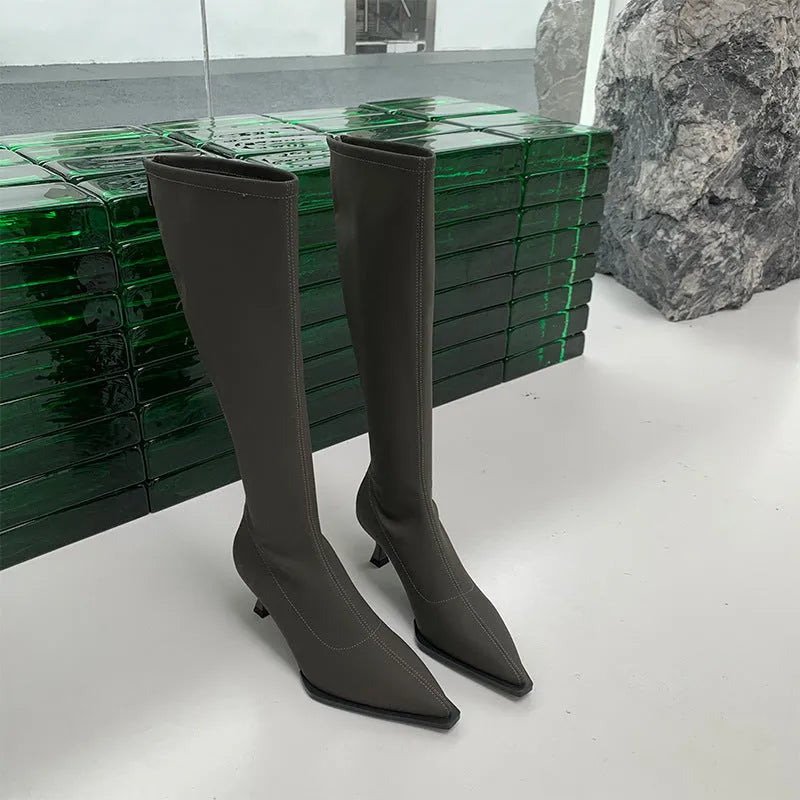 Black pointed toe women's ankle boots with a stiletto heel and a back zipper closure.