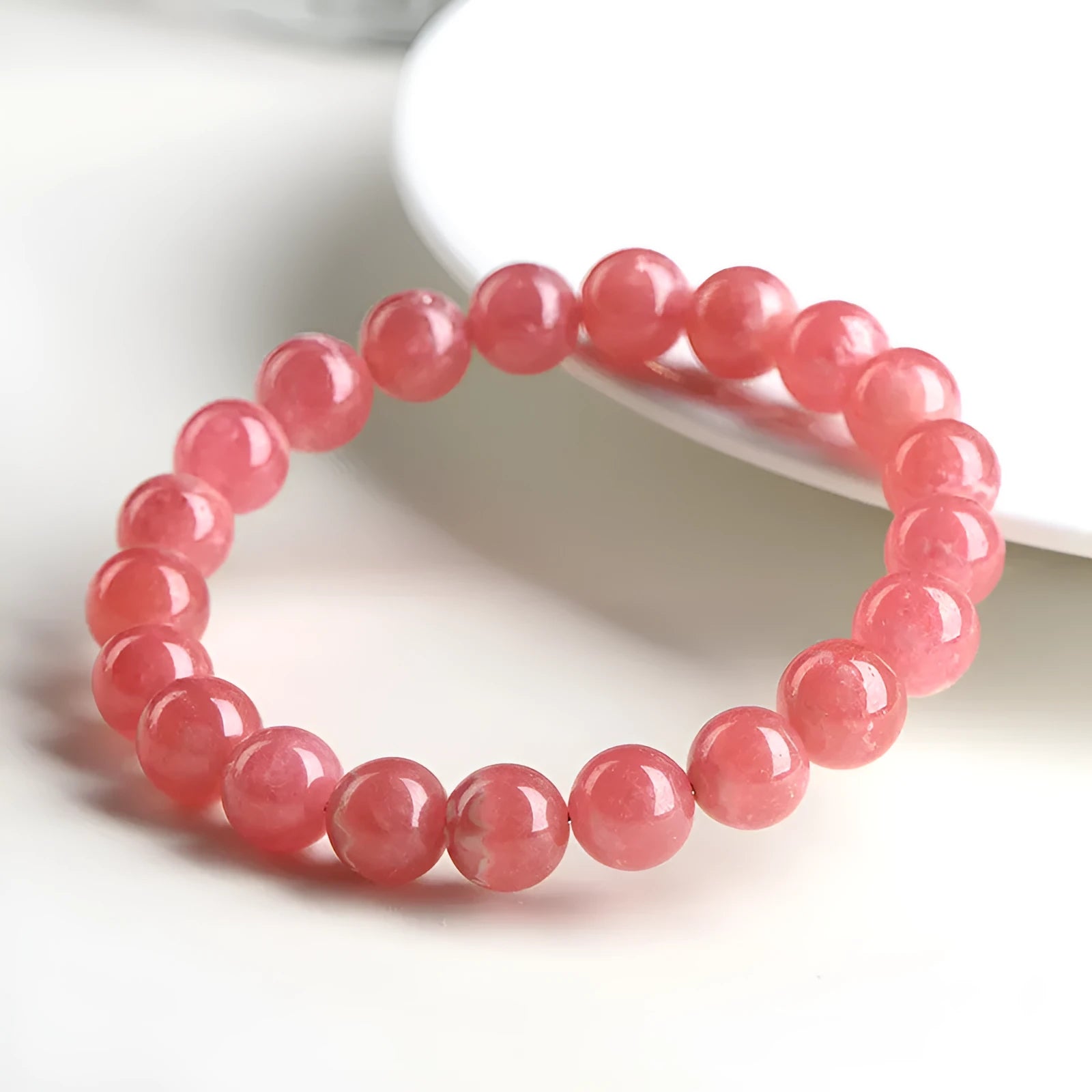Women's geometric crystal bracelet with Longevity Lock design and red rhodochrosite stone beads.