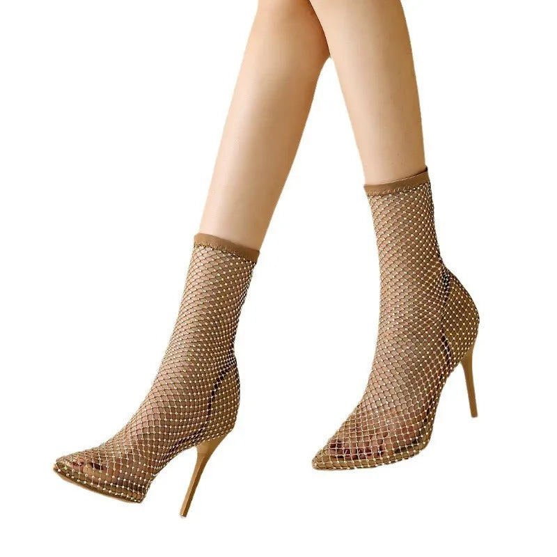 Gold high heel sandals with mesh upper and pointed stiletto heel on a rubber sole.