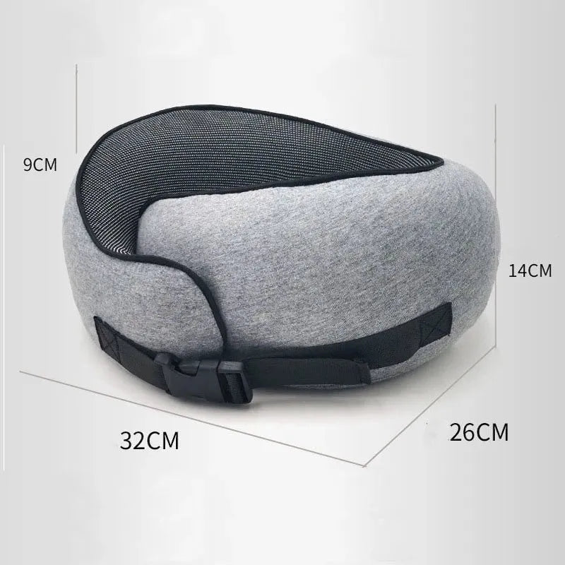 U-shaped navy blue travel neck pillow with memory foam, shown rolled up next to its carry bag.