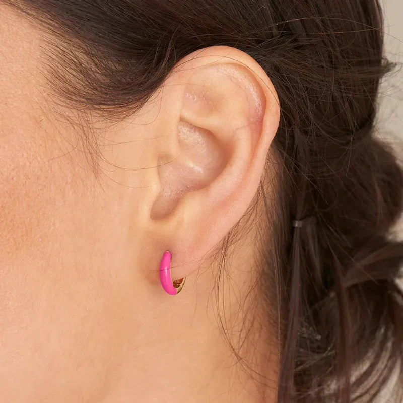 Pair of curved oval epoxy earrings in geometric ring design on a U-shaped hook.