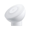 White modern bedside table lamp with sensor and Bluetooth on a wooden nightstand.
