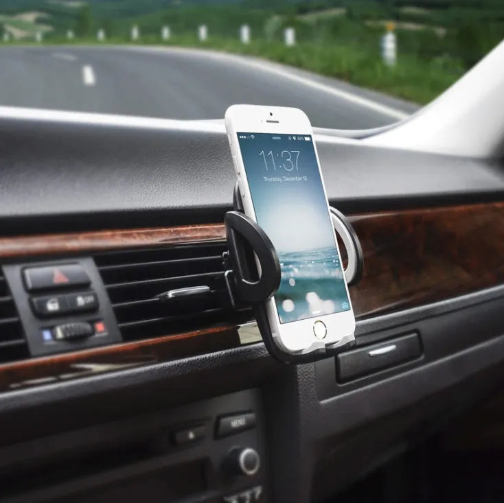 Black plastic mobile phone holder mounted on car air conditioning vent with phone in cradle
