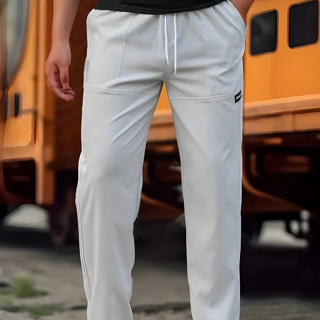 Men's light grey polyester trousers for spring and autumn wear, laid flat.